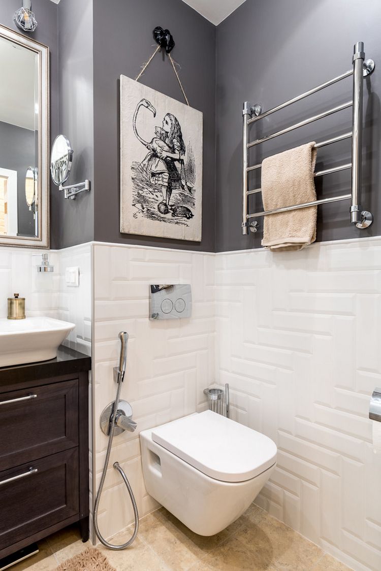 Bồn toilet được gắn tường để giải phóng diện tích mặt sàn, kệ treo khăn tắm được thiết lập trên tường để tận dụng bề mặt này hiệu quả. Một bức tranh cô gái màu trắng đen cũng tăng thêm tính thẩm mỹ cho phòng tắm.
