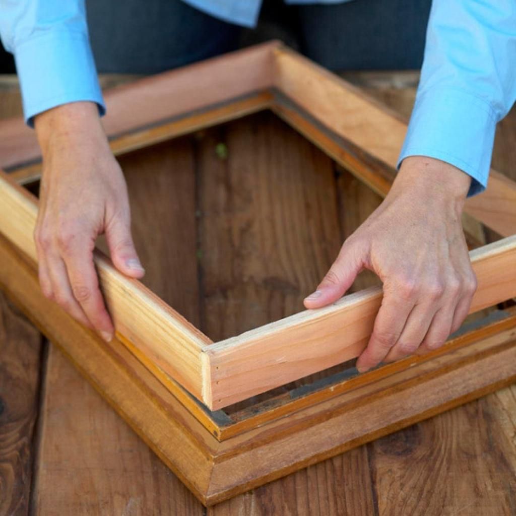 Đo khung tranh và dùng cưa cắt một tấm gỗ vừa với mặt sau của khung.