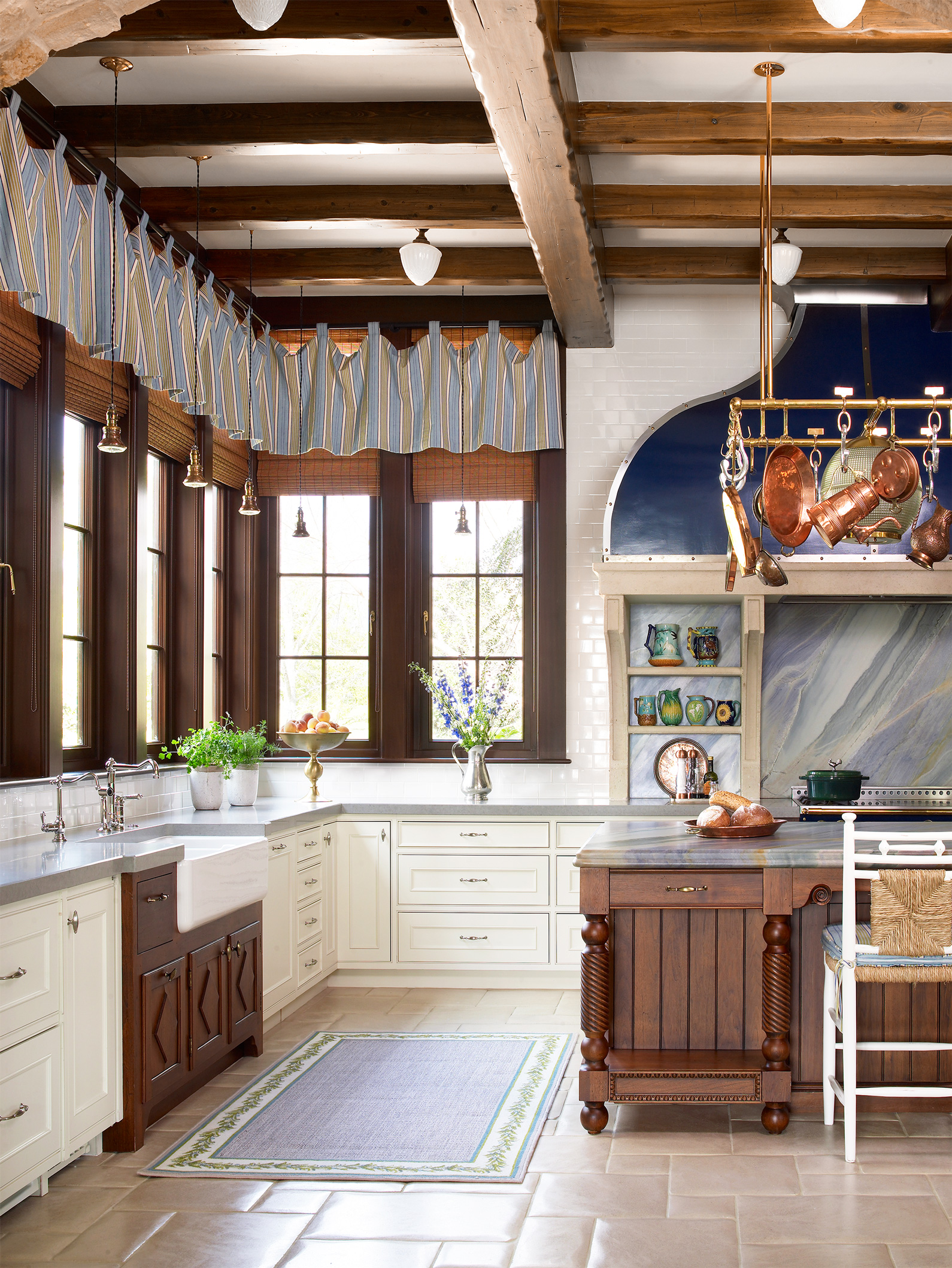 Vật liệu gỗ mộc tối màu dường như đang thống trị phòng bếp này, chính vì thế, một tấm rèm che kẻ sọc màu xanh dương và xám sẽ làm giảm đi sự thô cứng của nội thất, khiến phòng bếp phong cách Rustic trở nên mềm mại, duyên dáng hơn.