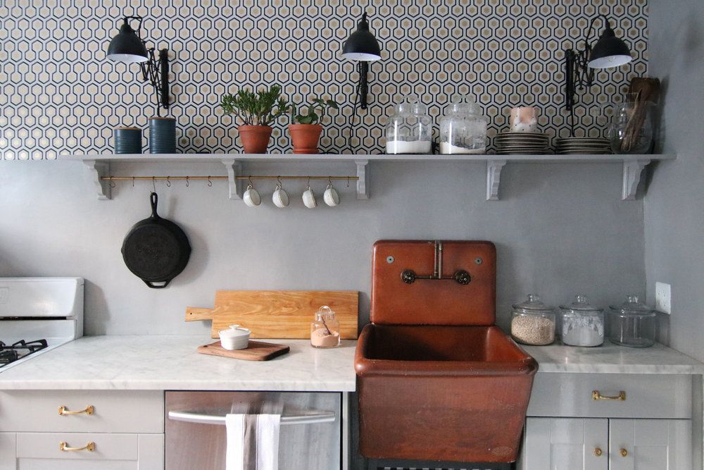 Phòng bếp sử dụng giấy dán tường hình lục giác cách điệu tuy đơn giản nhưng tạo nên sự nhẹ nhàng, xinh xắn. Chiếc bồn rửa bọc da cổ điển giữa những món nội thất làm từ vật liệu hiện đại càng khiến không gian thêm phần độc lạ.