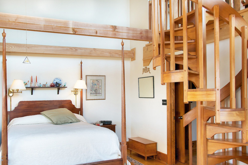 Cầu thang xoắn ốc bằng gỗ sáng màu với thiết kế vững chãi, đồng bộ với các món nội thất trong phòng ngủ tạo nên sự liên kết hài hòa, đẹp mắt và ấm cúng.