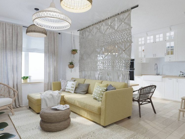Sofa góc màu vàng nhạt được đặt trên tấm thảm dệt trang nhã, nổi bật giữa gam màu xám chủ đạo của căn phòng. Chiếc bàn nước đan liễu gai nhẹ nhàng và duyên dáng. 