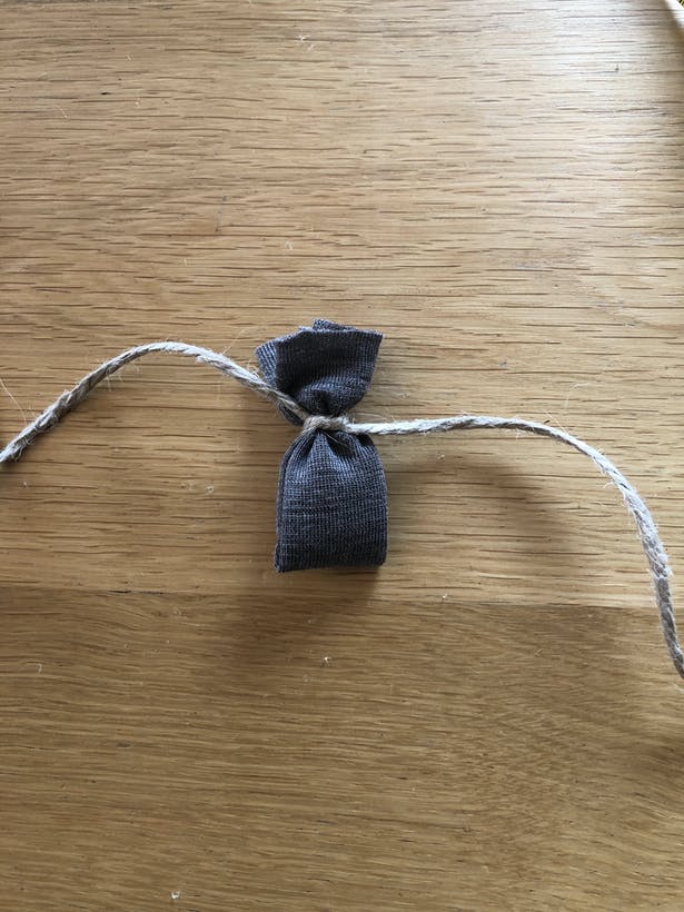 Làm nơ thì rất đơn giản, bạn chỉ cần gấp miếng vải thành hình chữ nhật và buộc dây đay ở giữa.