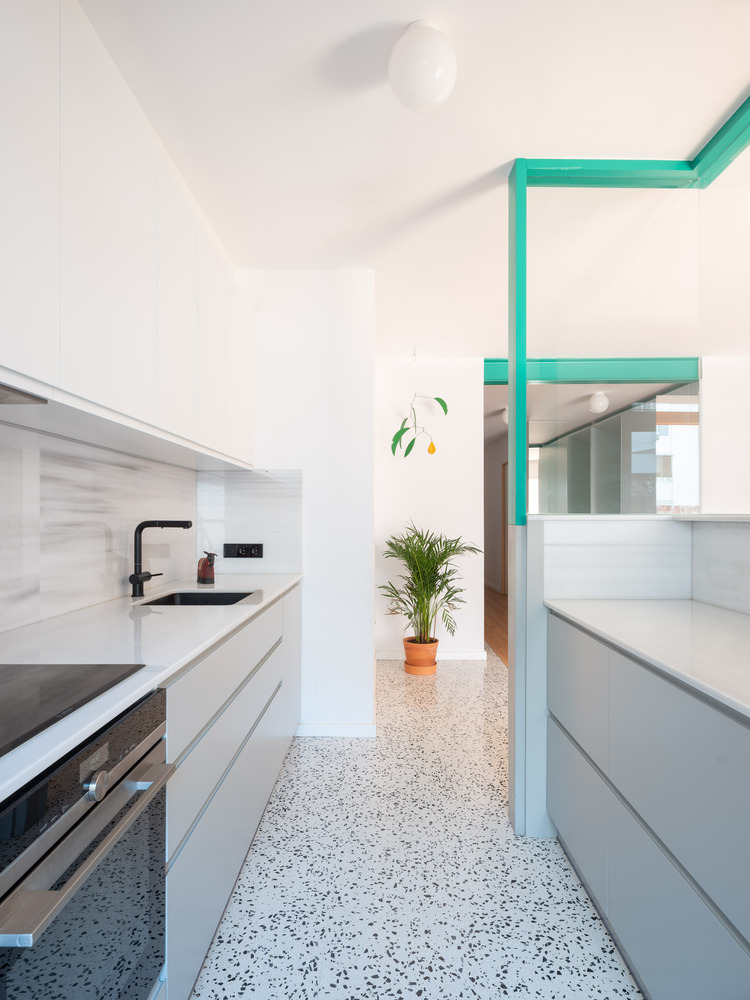 Sàn gạch terrazzo màu xám xanh đánh dấu khu vực phòng bếp, nội thất tối giản, tiện nghi và sang trọng với bề mặt hoàn thiện sáng bóng.