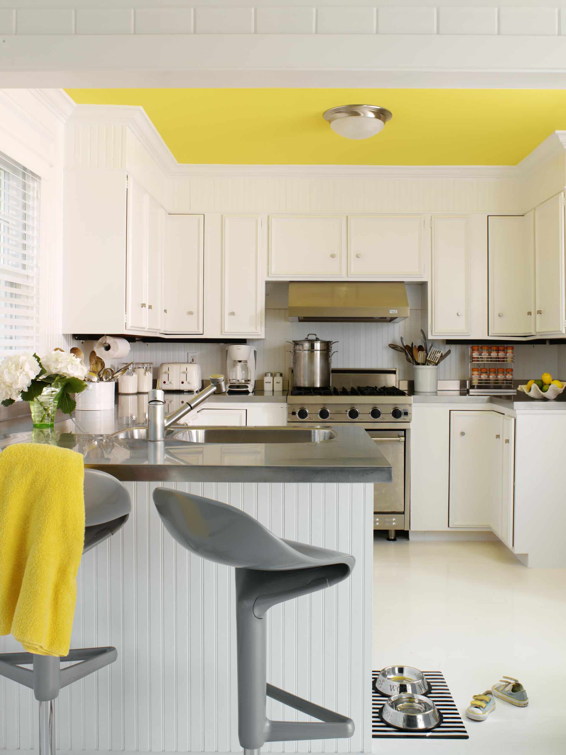 Đôi khi, sự phối hợp màu sắc không nhất thiết chỉ đến từ nội thất cơ bản. Chẳng hạn như phòng bếp màu xám chủ đạo này, bạn chỉ cần sơn trần nhà và vắt một chiếc khăn màu vàng lên ghế thôi là cũng đủ tạo nên điểm nhấn.