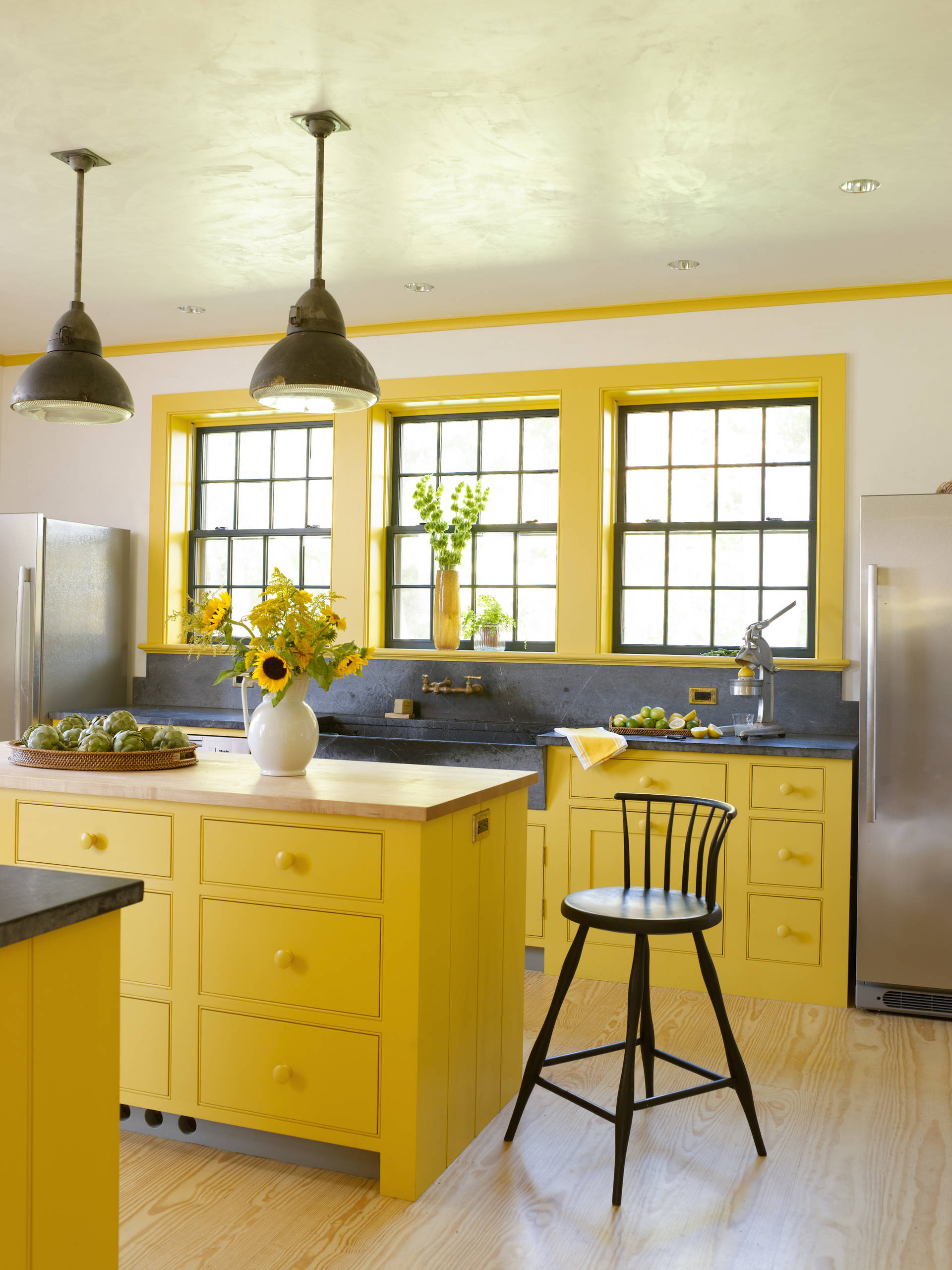 Phòng bếp xinh đẹp như một bức tranh khiến ai cũng tràn đầy năng lượng tích cực khi bước vào. Từ màu sơn của tủ, đảo bếp, khung cửa sổ cho đến hoa hướng dương rực rỡ. Lúc này, màu xám đậm lại trở thành điểm nhấn để màu vàng tỏa sáng!