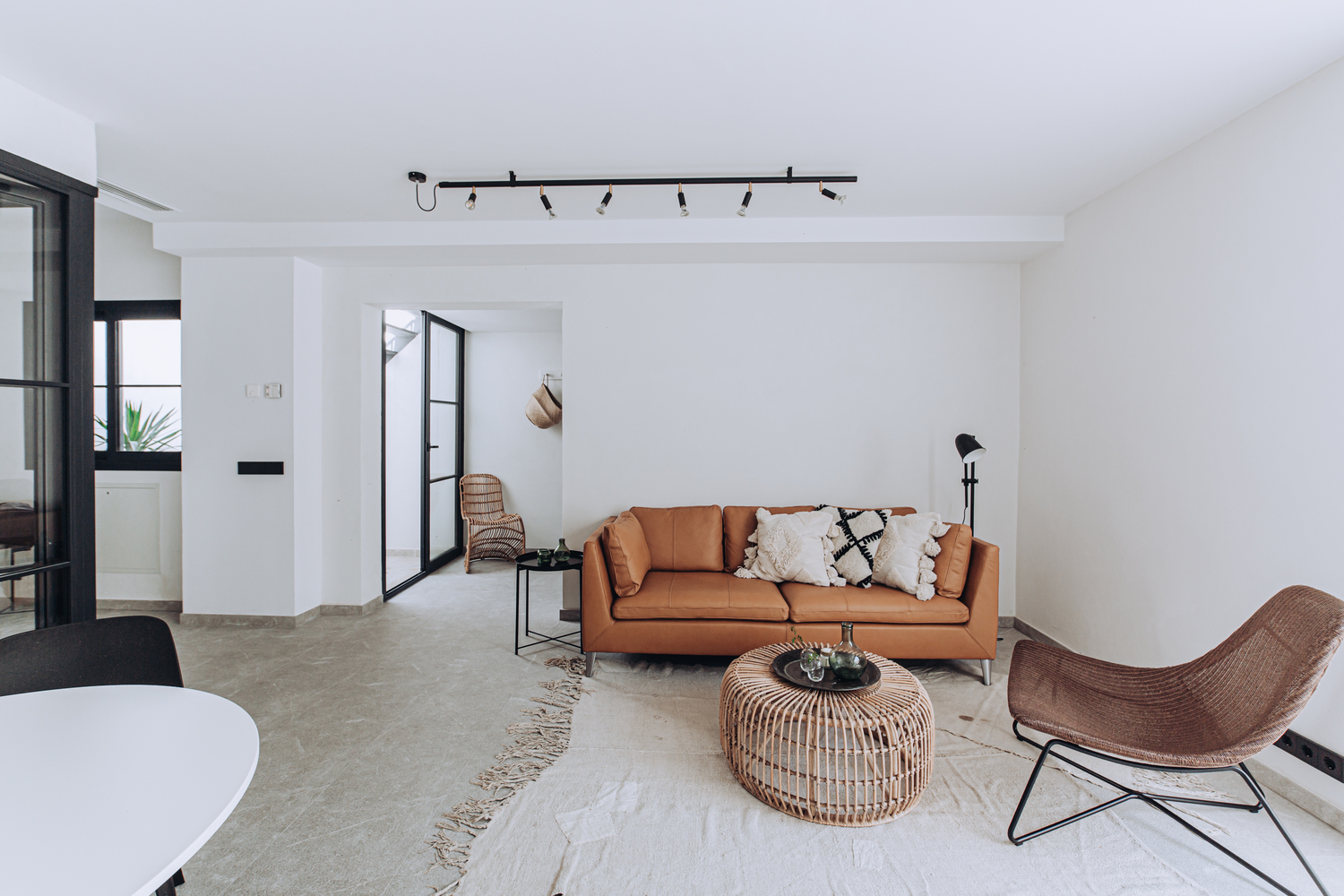 Phòng khách gần gũi với ghế sofa màu nâu cùng vài chiếc gối tựa ấm áp, tấm thảm trải sàn giản dị phân vùng phòng khách với những khu vực khác.