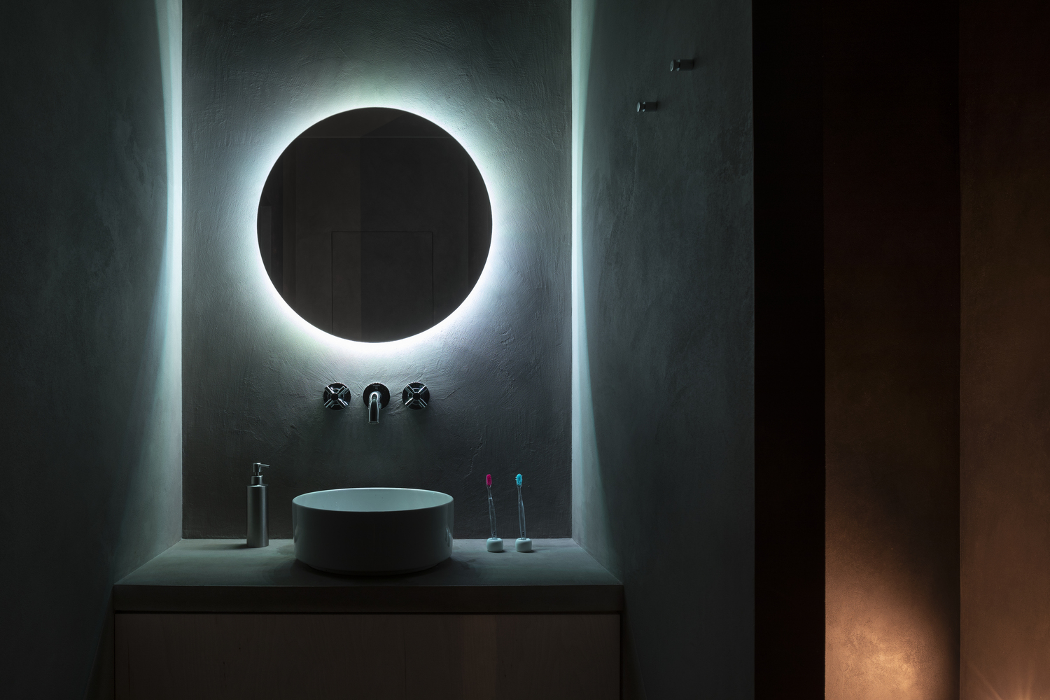 Không chỉ riêng phòng ngủ, cả phòng tắm nhỏ cũng được chủ nhân đầu tư hệ thống đèn chiếu sáng xung quanh tấm gương tròn cho cảm giác lôi cuốn đầy mạnh mẽ và nam tính.