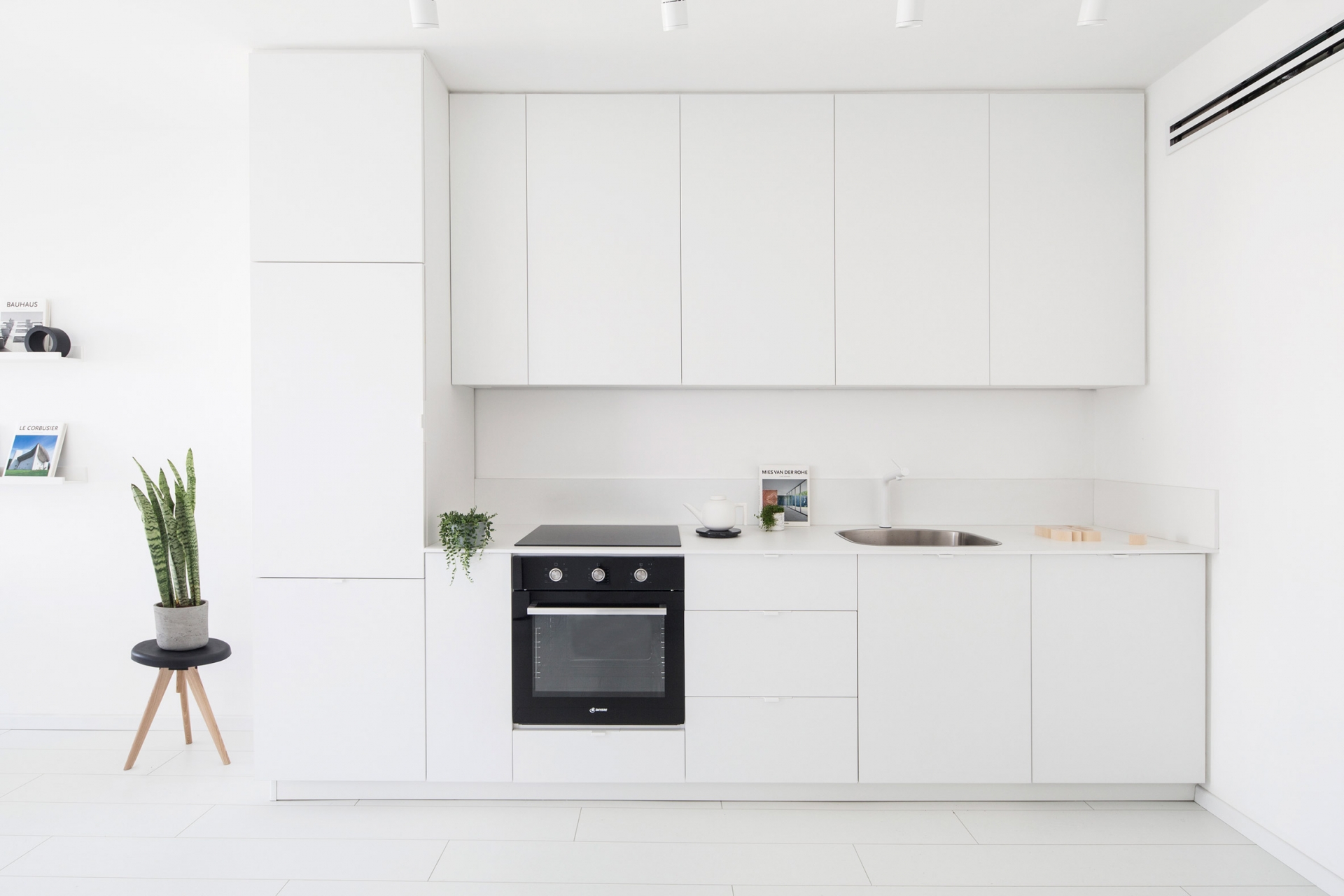 Tủ bếp thiết kế chữ I, vừa phù hợp với cấu trúc của căn hộ vừa là giải pháp thông minh giúp tiết kiệm không gian mà vẫn đảm bảo các yếu tố cơ bản đáp ứng cho công việc bếp núc. Chiếc lò nướng màu đen cũng trở thành điểm nhấn bắt mắt trong khu vực này.
