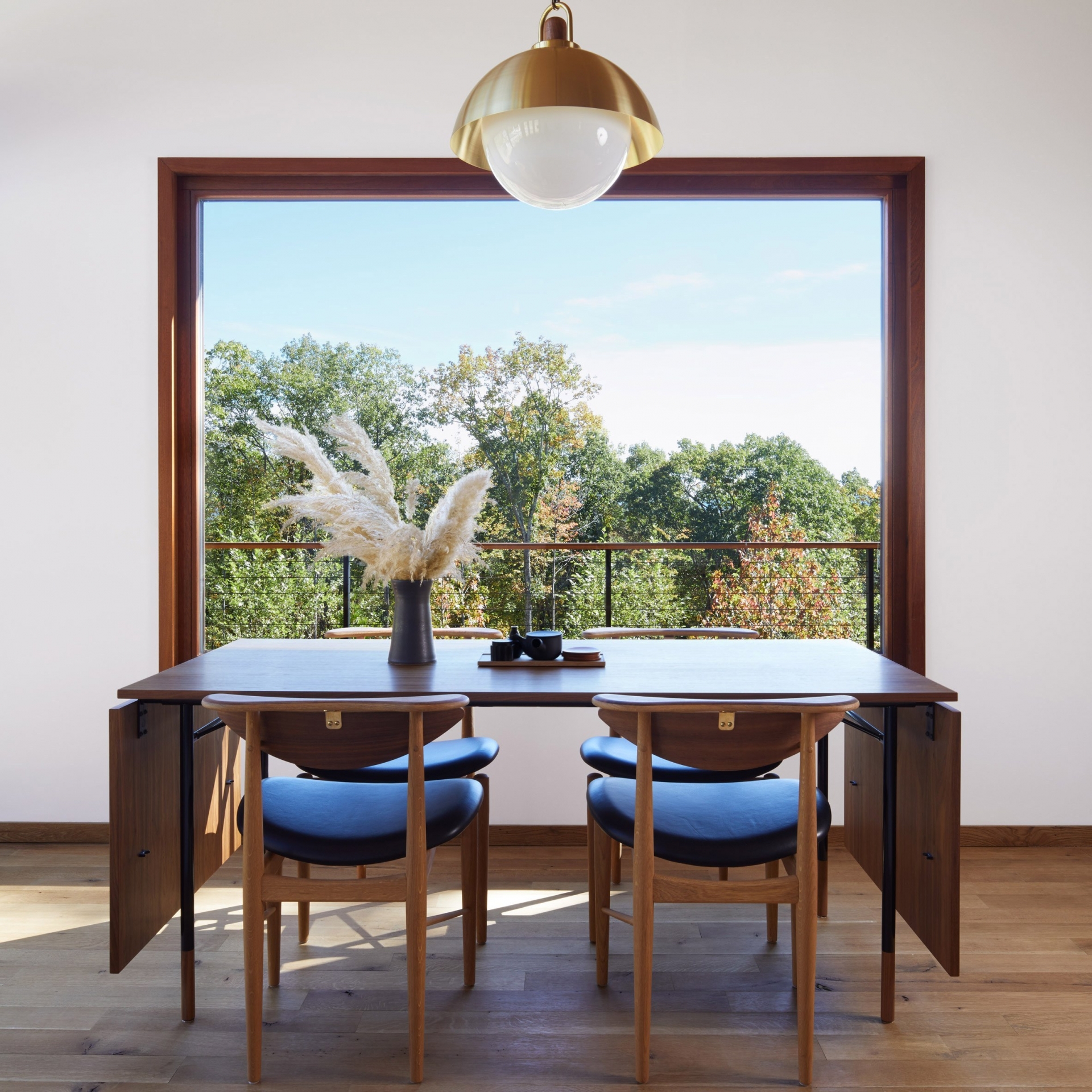 Phòng ăn của ngôi nhà tại New York thiết kế đơn giản với chiếc bàn ăn có thể gấp gọn - một trong số những món nội thất được nhập khẩu từ Đan Mạch. Chiếc bàn có kích thước vừa vặn với khung cửa sổ vuông vắn nhìn ra khung cảnh bên ngoài.