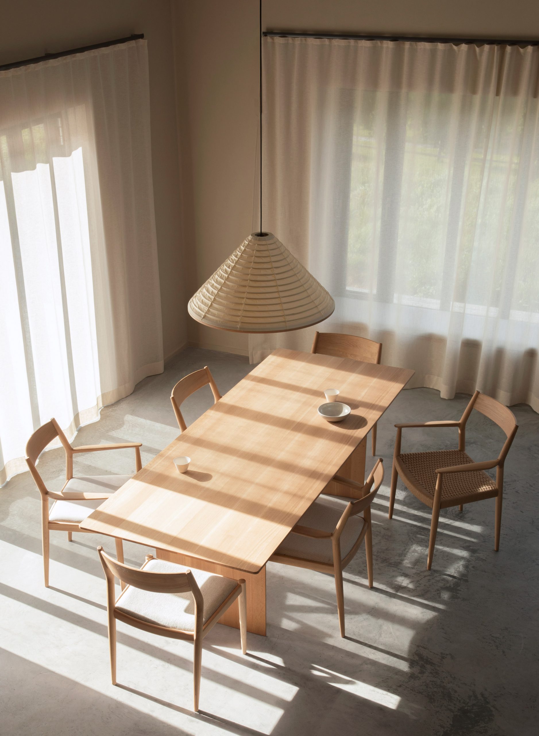 Từ trên cao nhìn xuống, khu vực ăn uống với bộ bàn ăn bằng gỗ đơn giản nhưng xinh đẹp, kết hợp với những tia nắng chiếu qua tấm rèm mỏng manh càng thêm phần tinh tế.