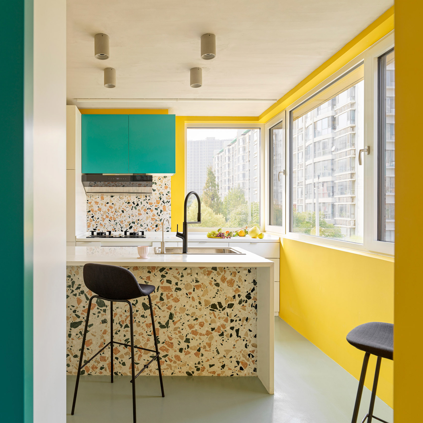 DDM Studio đã kết hợp những bức tường màu vàng rực rỡ với nội thất (tủ bếp) sơn màu xanh ngọc, gạch terrazzo ở khu vực backsplash và đảo bếp kết hợp ô cửa kính đầy nắng cho cái nhìn tươi tắn, đầy sức sống.