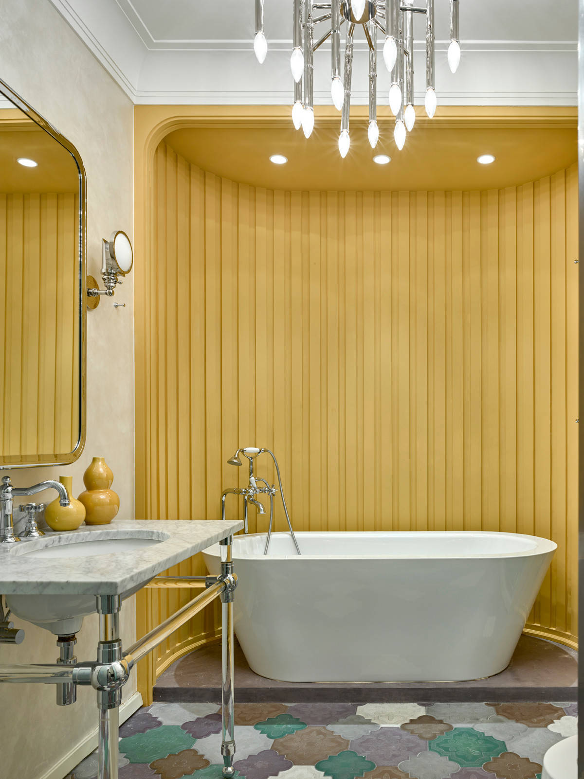 Bức tường sơn vàng cùng gạch lát sàn nhiều màu sắc cho phòng tắm rạng ngời.