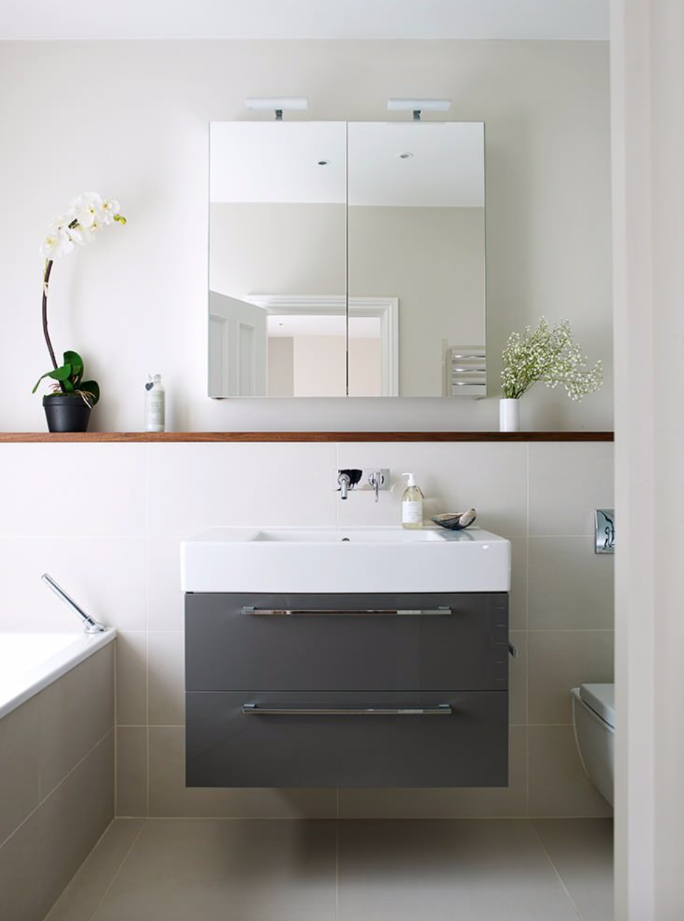 Tủ lưu trữ cửa gương giúp phòng tắm trở nên tinh tế, hiện đại và tươi sáng.