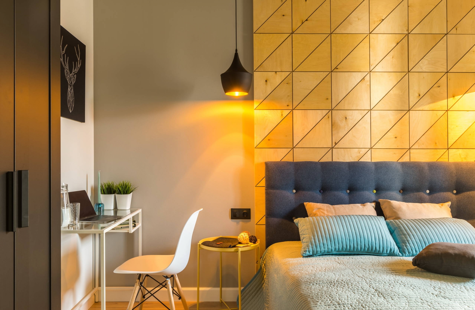 Căn phòng chỉ có duy nhất chiếc bàn nhỏ đầu giường là sơn màu vàng, thế nhưng hiệu ứng ánh sáng vàng ấm kết hợp vật liệu gỗ đã khiến sắc vàng bao phủ không gian.