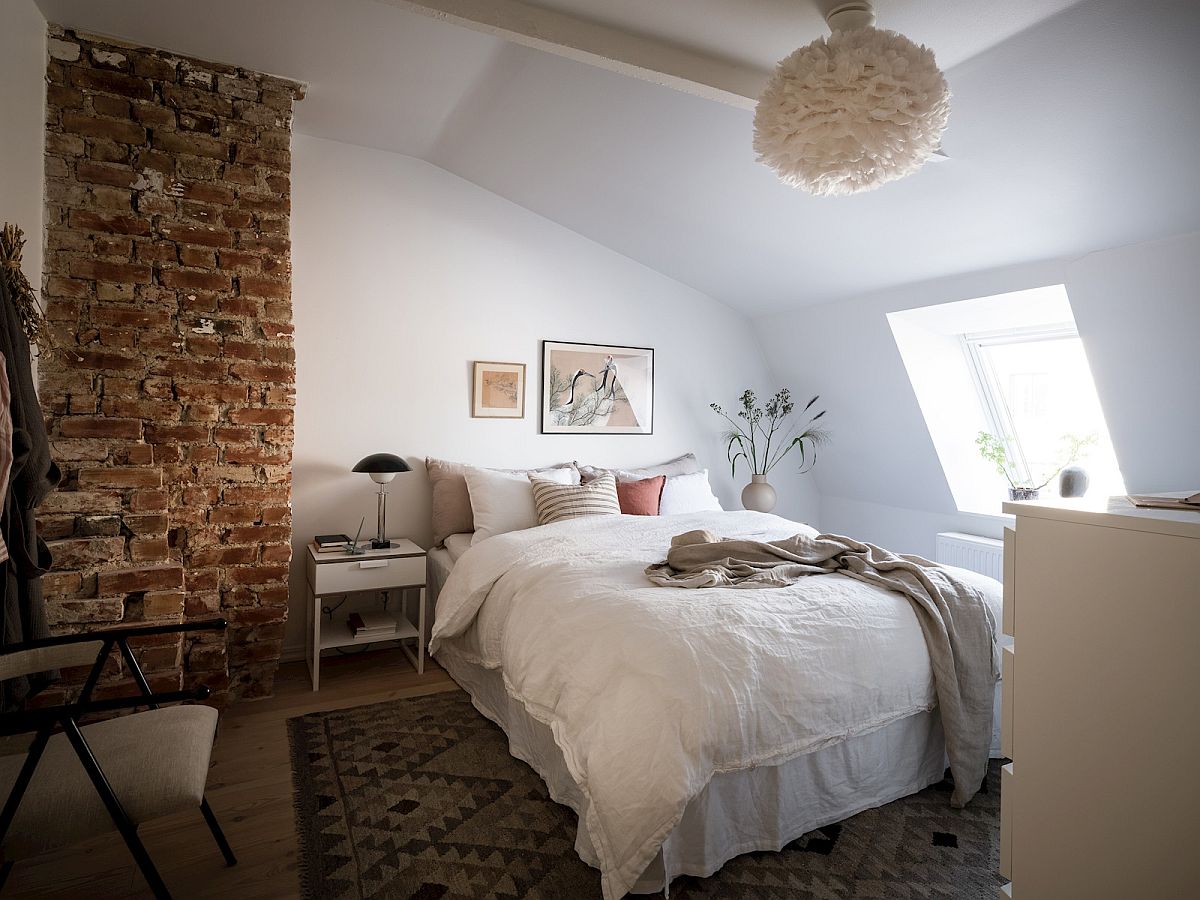 Phần tường gạch thô mộc mang đến hình ảnh thú vị và tăng thêm độ tương phản cho phòng ngủ nhỏ.