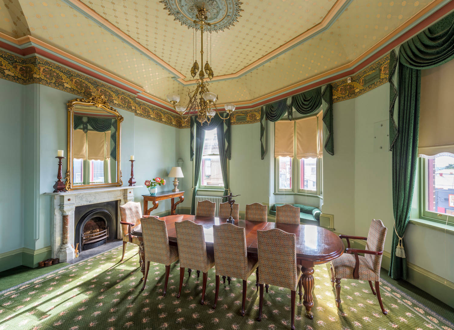 Phòng ăn phong cách Victoria với trần nhà trang trí cực kỳ công phu, rèm cửa sổ và thảm trải sàn phủ kín phòng ăn với màu xanh lá tươi tắn.