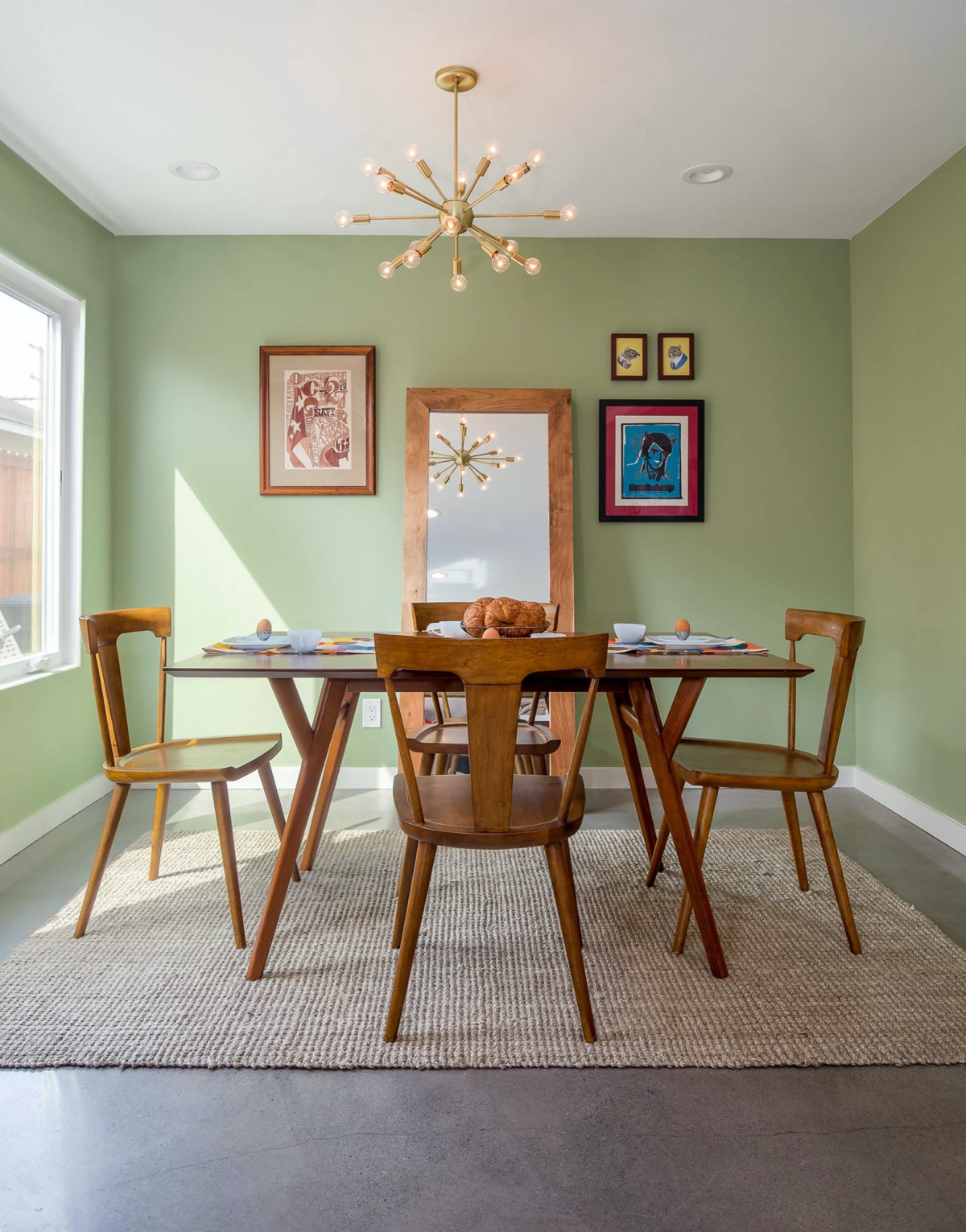 Phòng ăn ấm áp tuyệt đối với sự kết hợp của màu xanh lá cây và nội thất gỗ, tấm gương lớn cho hiệu ứng phản chiếu ánh sáng cho căn phòng càng thêm thoáng đãng.