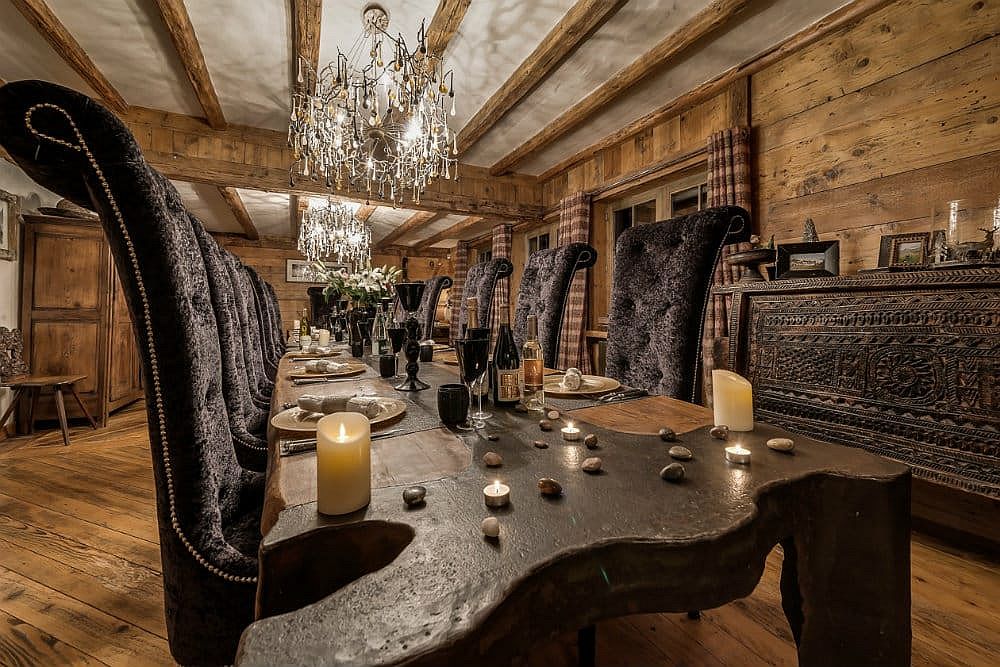 Không gian ăn uống tiện nghi với bàn ăn lớn bằng gỗ, bộ ghế đen huyền bí cùng những ánh nến lung linh.
