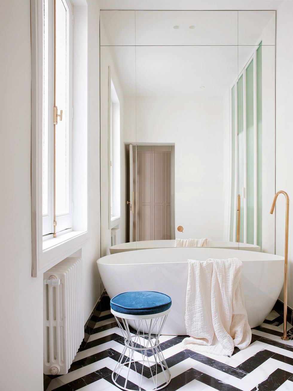 Phòng tắm nhỏ nhưng lại tạo cảm giác siêu rộng nhờ bức tường ốp gương kín từ khu vực trần đến sàn nhà. Bồn tắm đơn giản nhưng thanh lịch với vòi nước bằng vàng đồng sang chảnh.