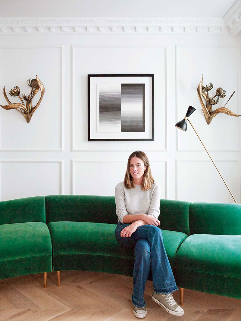 Nhà thiết kế nội thất María Santos, một trong hai nhà thiết kế chính của căn hộ này, trên chiếc ghế màu xanh lá vải nhung tuyệt đẹp nơi phòng khách.