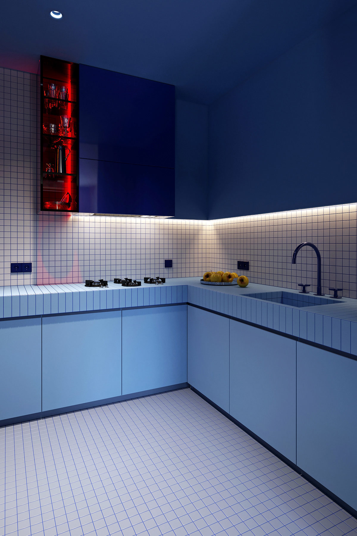 Khu vực nấu nướng được thiết kế với kiểu tủ chữ L phù hợp với cấu trúc của căn hộ và sử dụng không gian hiệu quả. Màu xanh đậm kết hợp với backsplash màu trắng kẻ ô vuông mang đến sự tương phản bắt mắt.