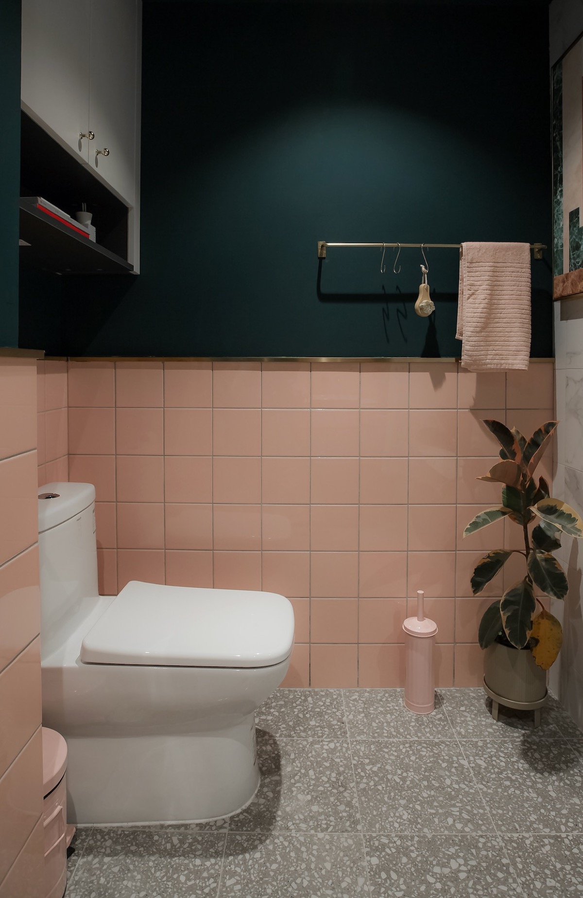 Phòng tắm lựa chọn nội thất và thiết kế cực kỳ đơn giản, đáp ứng những nhu cầu cơ bản nhưng vẫn hút mắt bởi sự thông minh khi chọn lựa sắc màu tương phản. Sơn tường màu xanh lá đậm kết hợp gạch ốp màu hồng tươi sáng thích hợp cho không gian nhỏ như thế này.
