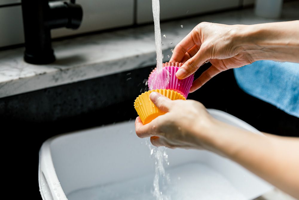 Rửa sạch vật dụng bằng silicone trong nước sạch.