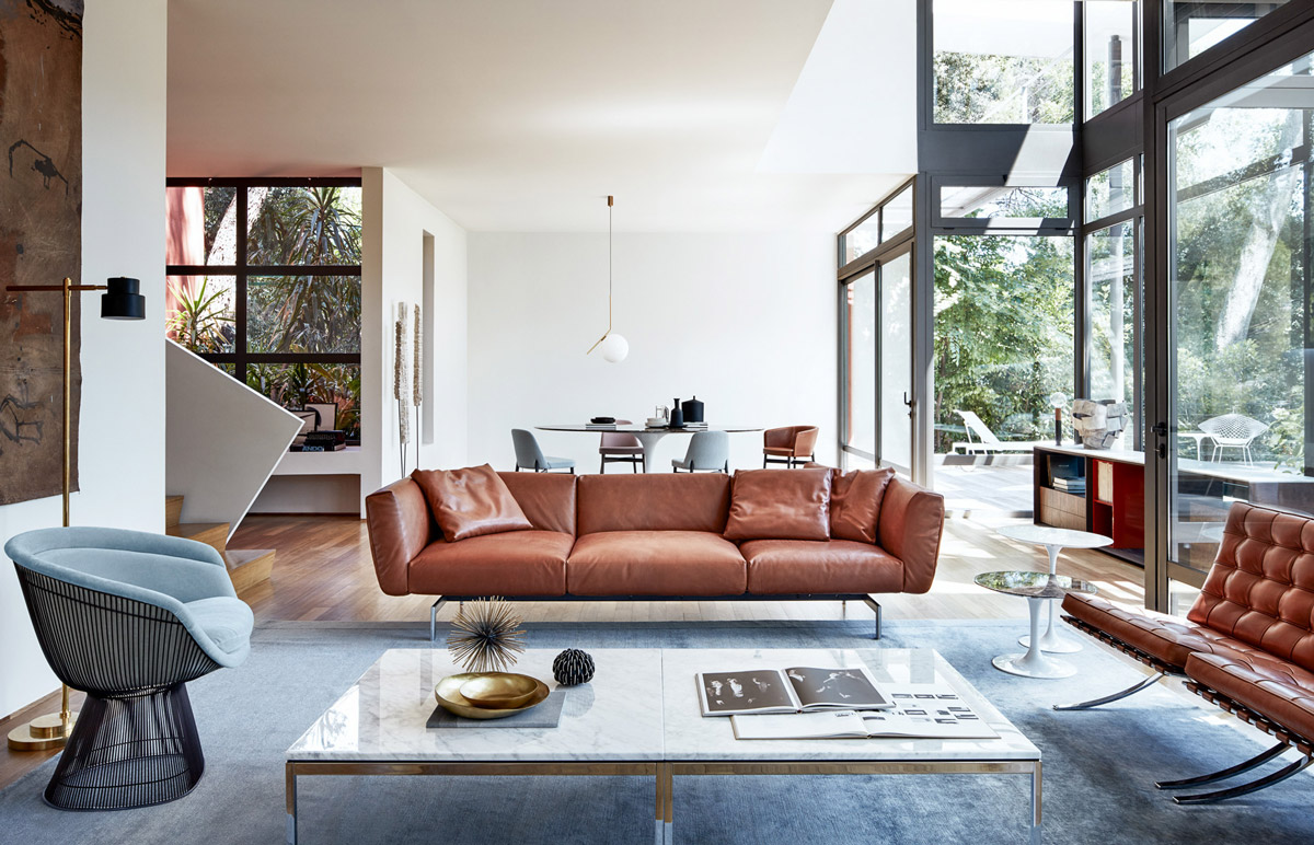 Trong phòng khách thiết kế mở hiện đại này, chiếc ghế sofa màu nâu hồng ấm áp kết hợp với ghế bành và thảm trải sàn màu xám, bộ đôi bàn nước mặt đá cẩm thạch tạo nên vẻ đẹp sang trọng và tinh tế.