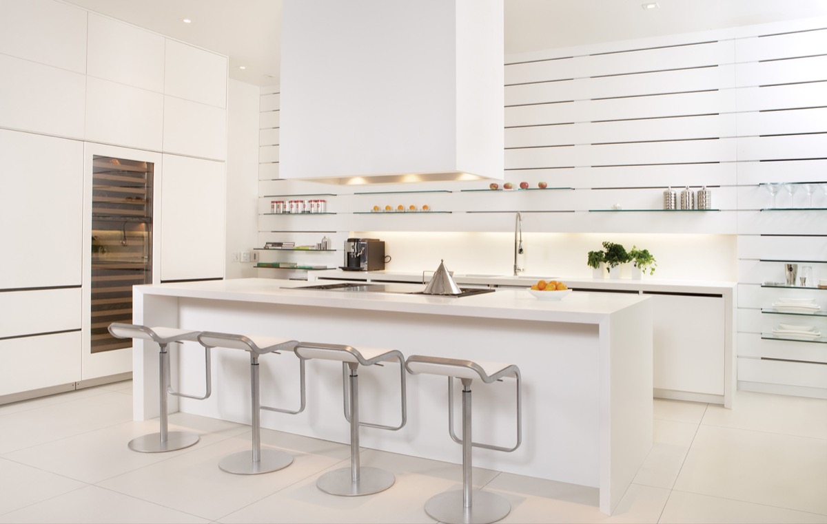 Một phòng bếp với thiết kế hệ thống kệ mở siêu đẹp bởi chúng ta không hề cảm thấy sự nặng nề, thô cứng của vật dụng lưu trữ. Trái lại, hàng chục tấm kính trong suốt có kích thước giống nhau được lắp đặt vững chắc trên bề mặt bức tường màu trắng tạo nên vẻ đẹp đồng bộ và hiện đại. 