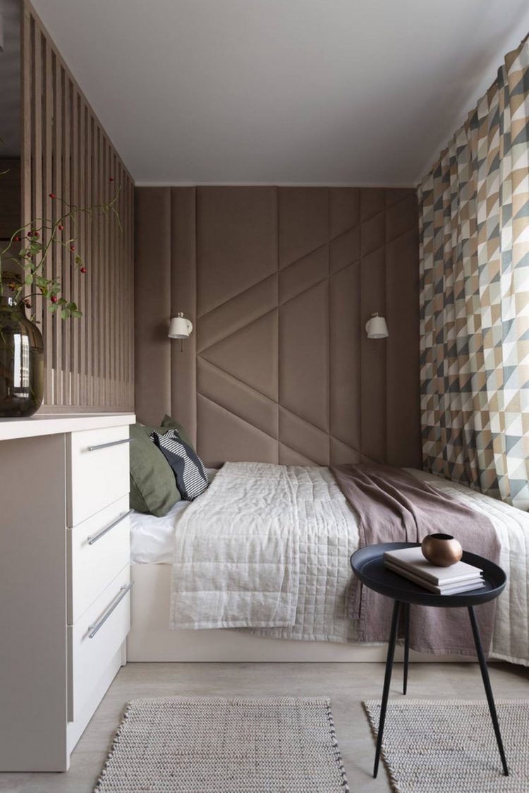 Chiếc giường nệm trắng giản dị làm nền cho những chiếc gối màu xanh hay bức tường nâu trở nên nổi bật. Tấm rèm họa tiết hình học kéo dài từ phòng ngủ sang phòng khách trông rất mềm mại và duyên dáng.