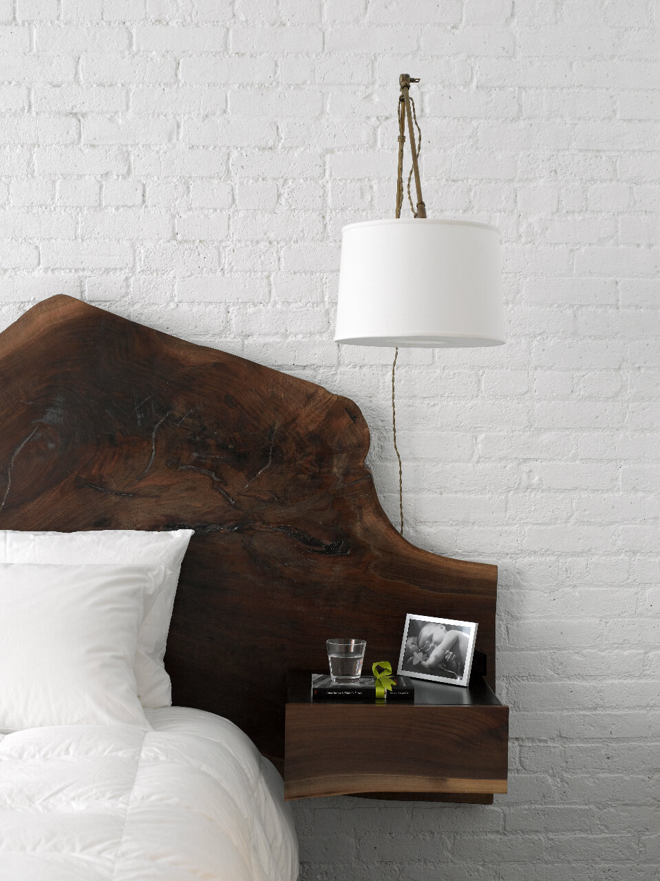 Bằng cách ghép tường gạch sơn trắng với táp đầu giường bằng gỗ màu trầm, phòng ngủ ngủ đã tạo nên cảm giác tương phản bắt mắt và không kém phần độc đáo.