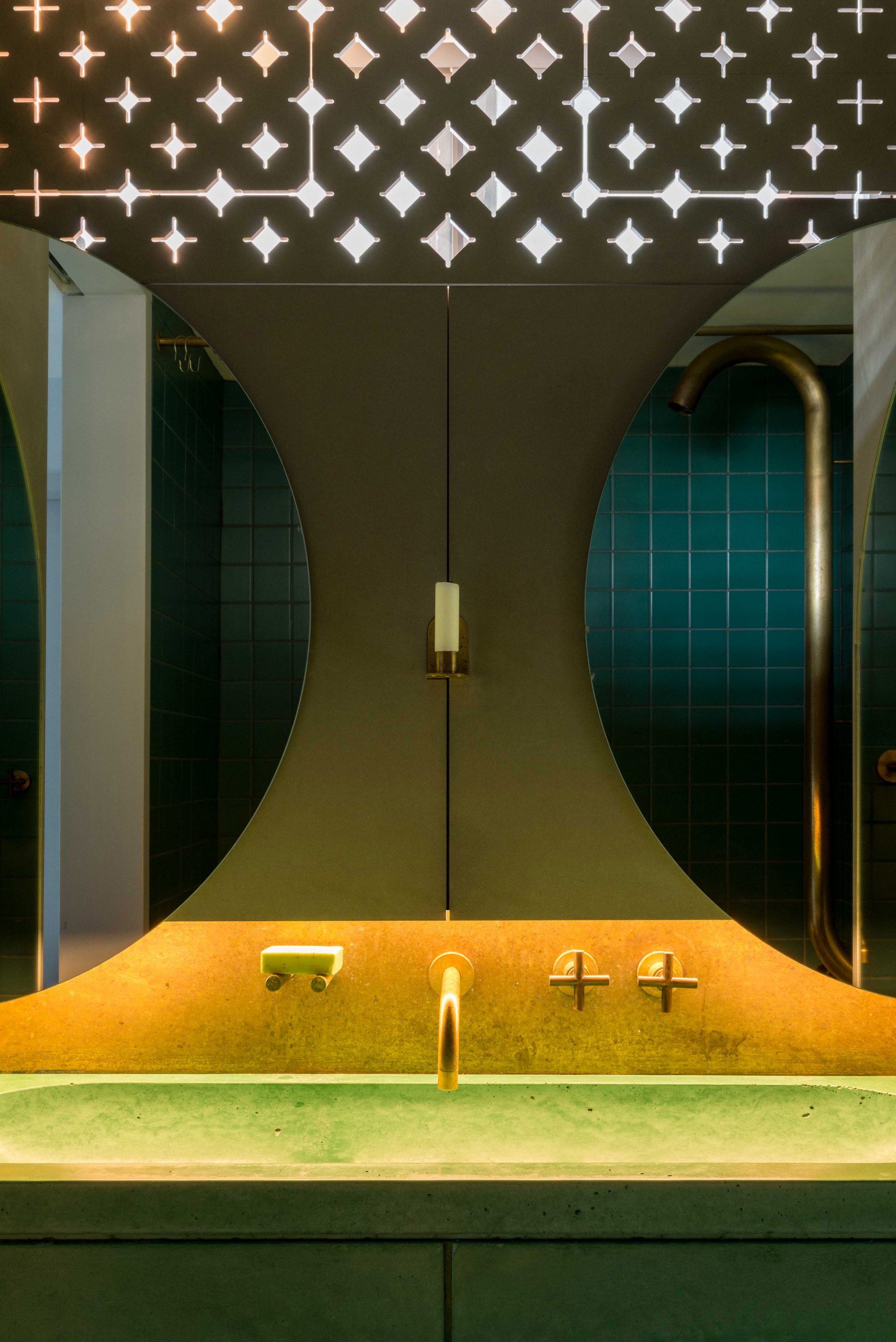 Để trang trí cho bức tường phòng tắm, Ben Allen đã lựa chọn 2 chiếc gương hình bán nguyệt (nửa vầng trăng) và bố trí ngược nhau cho cái nhìn vô cùng lạ mắt và ấn tượng. Cửa chớp đục lỗ cho phép một lượng ánh sáng tự nhiên tràn vào đầy tính nghệ thuật.