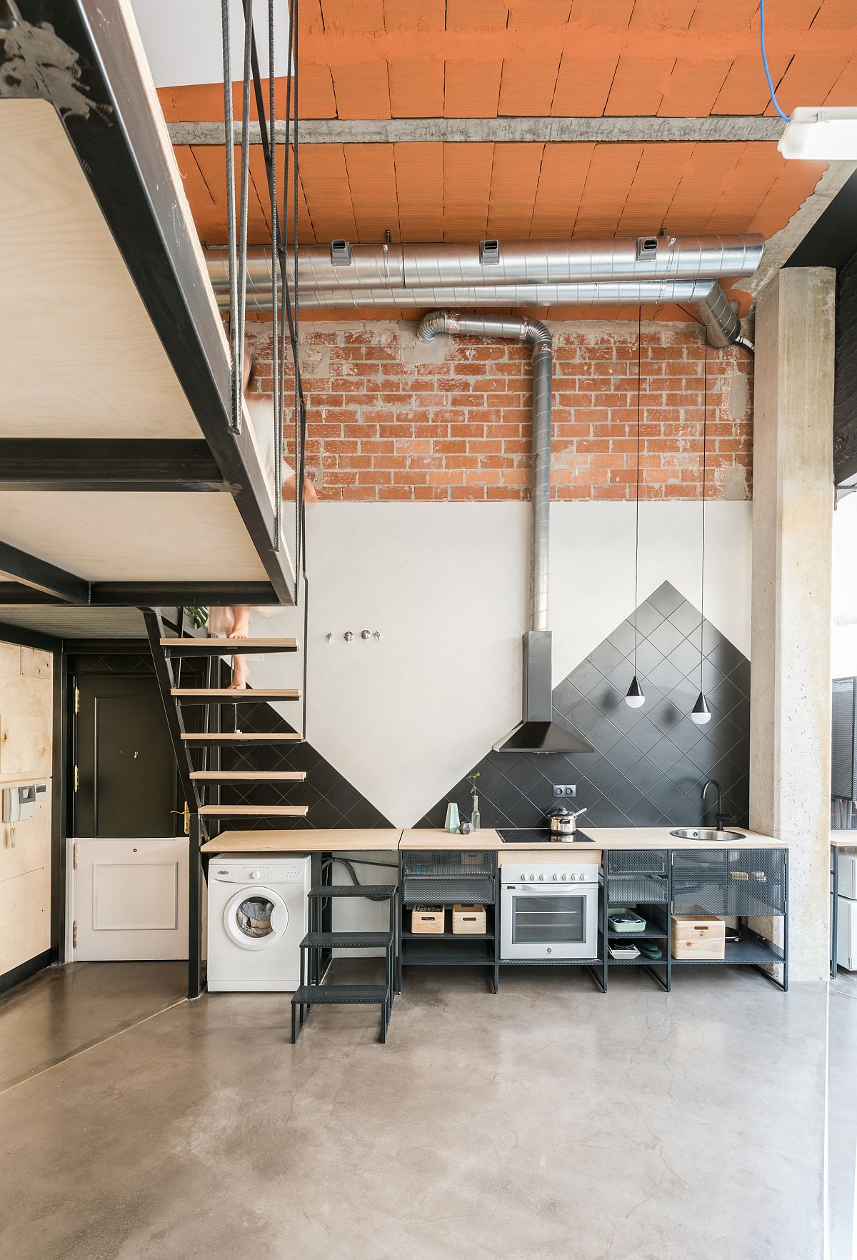 Phòng bếp độc đáo với bức tường hai gam màu đen - trắng trang trí theo kiểu hình học tam giác màu đen tạo chiều sâu nổi bật cũng như thuận tiện hơn trong việc giữ vệ sinh ở không gian nấu nướng.