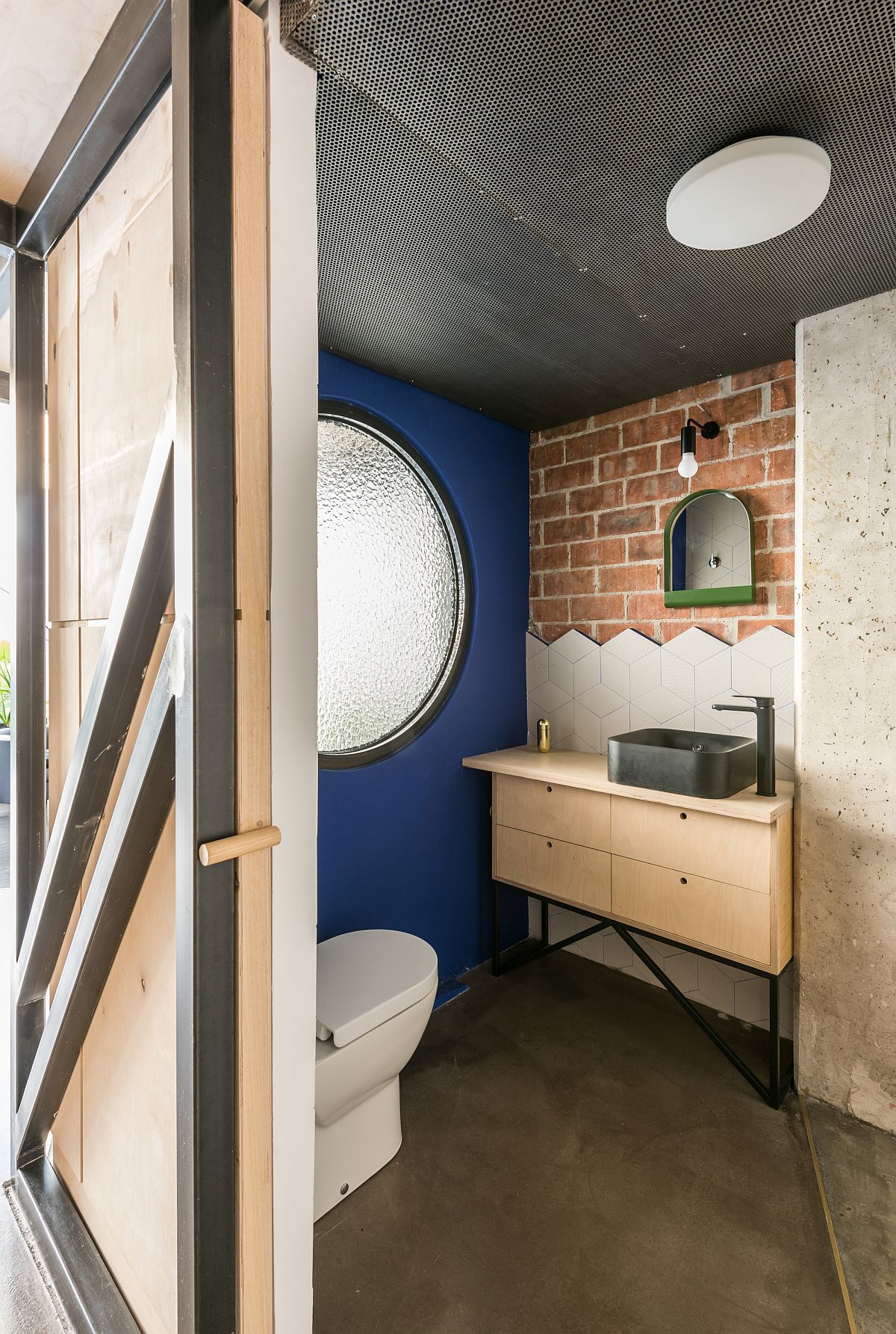 Cửa trượt phân tách phòng tắm với khu vực sinh hoạt chung, tủ lưu trữ kết hợp bồn rửa tiện ích cùng góc tường nhỏ nhưng được thiết kế ấn tượng.