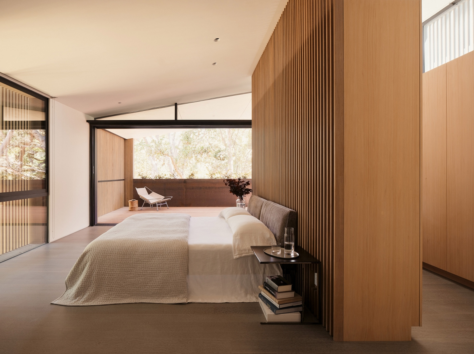 Phòng ngủ đơn giản nhưng xinh xắn, phân tách với góc thư giãn bằng cửa kính trong suốt, vì thế có thể đón nhận ánh sáng tự nhiên thông suốt cả căn phòng.