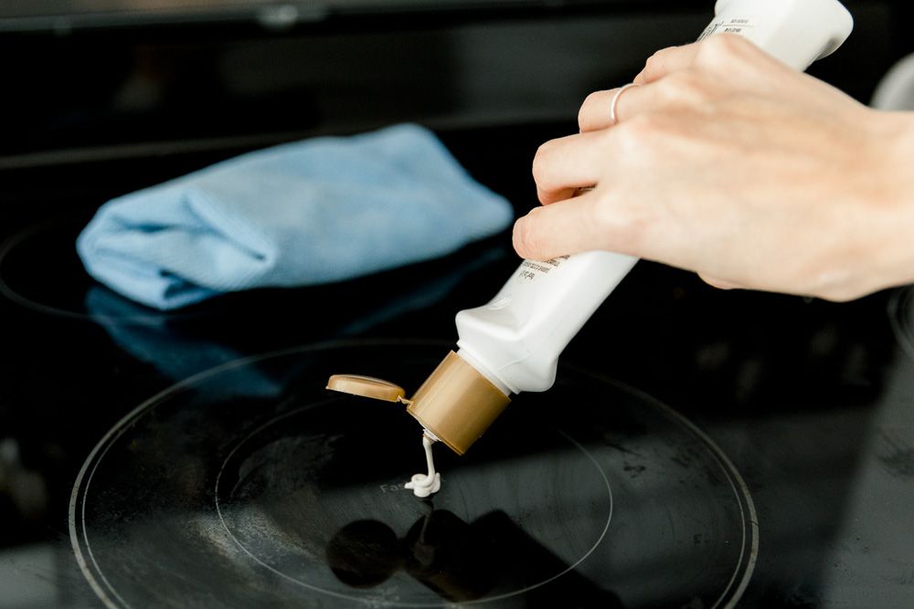 Dùng kem tẩy đa năng cho bề mặt kính hoặc tự chế hỗn hợp gồm giấm trắng và baking soda để loại bỏ thức ăn bị cháy bám trên mặt bếp.