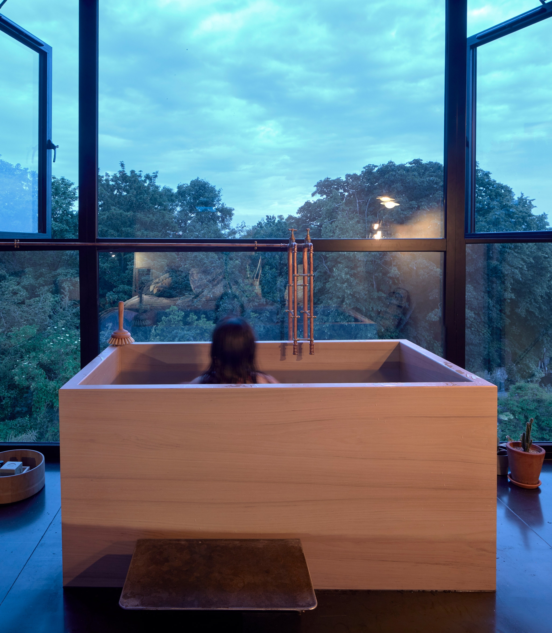 Chiếc bồn tắm đặt tựa vào cửa sổ lớn theo phong cách quen thuộc của xứ sở Phù Tang. Chủ nhân có thể nằm thư giãn và phóng tầm mắt chiêm ngưỡng thiên nhiên trong lành ngoài ô cửa.
