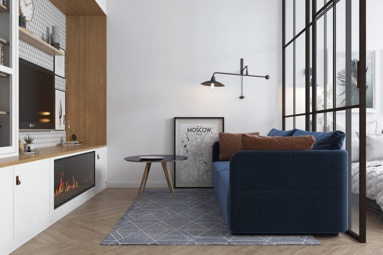 Phòng khách đơn giản với chiếc ghế sofa màu lam đậm nổi bật trên tấm thảm đóng vai trò phân vùng khu vực chức năng trên thiết kế mở của căn hộ có diện tích 58m².