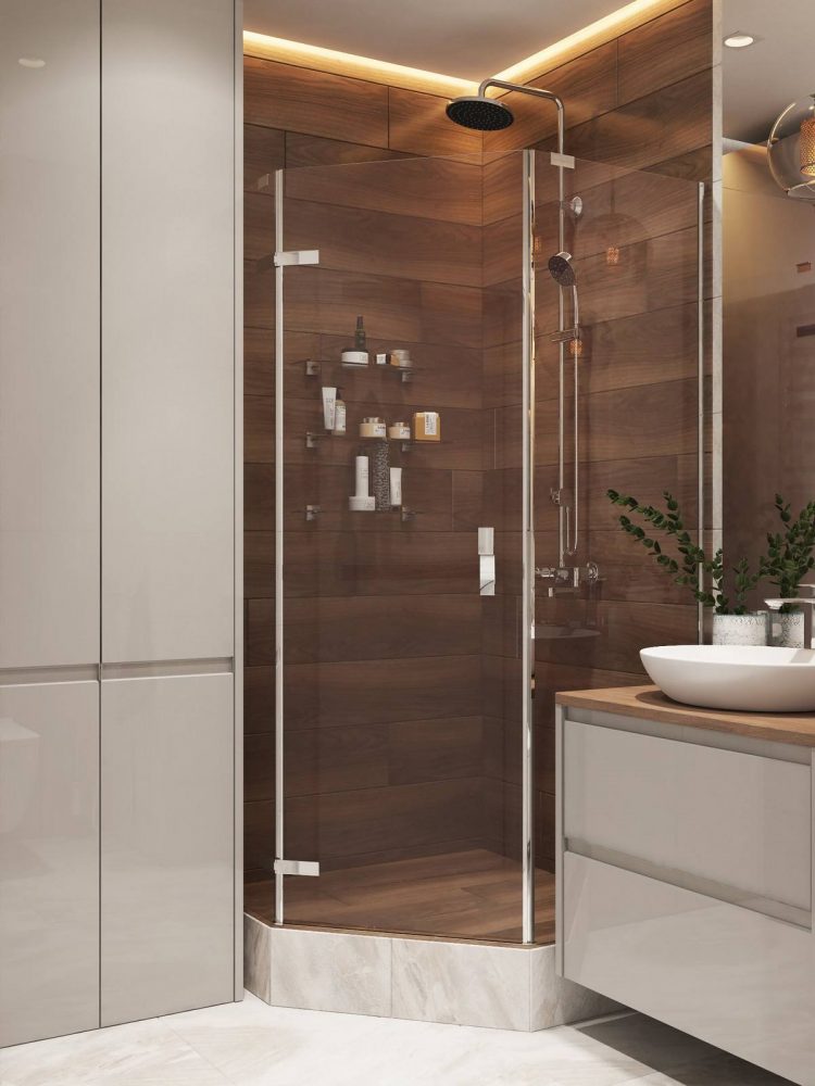 Bên trong buồng tắm được ốp gỗ tối màu tạo sự tương phản với sắc trắng của nhà vệ sinh. Hệ thống đèn LED trên trần kết hợp với đèn thả trước gương soi cho vẻ đẹp ấm áp và hoàn hảo.