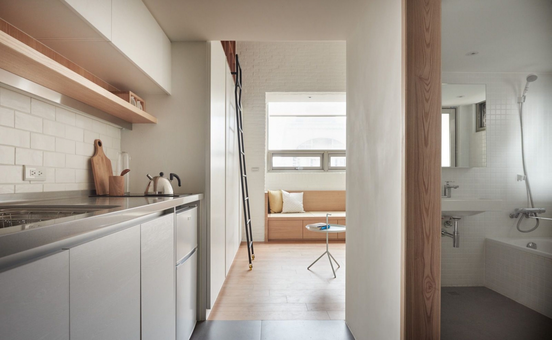 Trở xuống tầng dưới của căn hộ, bạn sẽ thấy phòng tắm được đặt song song với phòng bếp nhưng cách nhau vách ngăn bằng gỗ với lớp sơn bề mặt màu trắng.