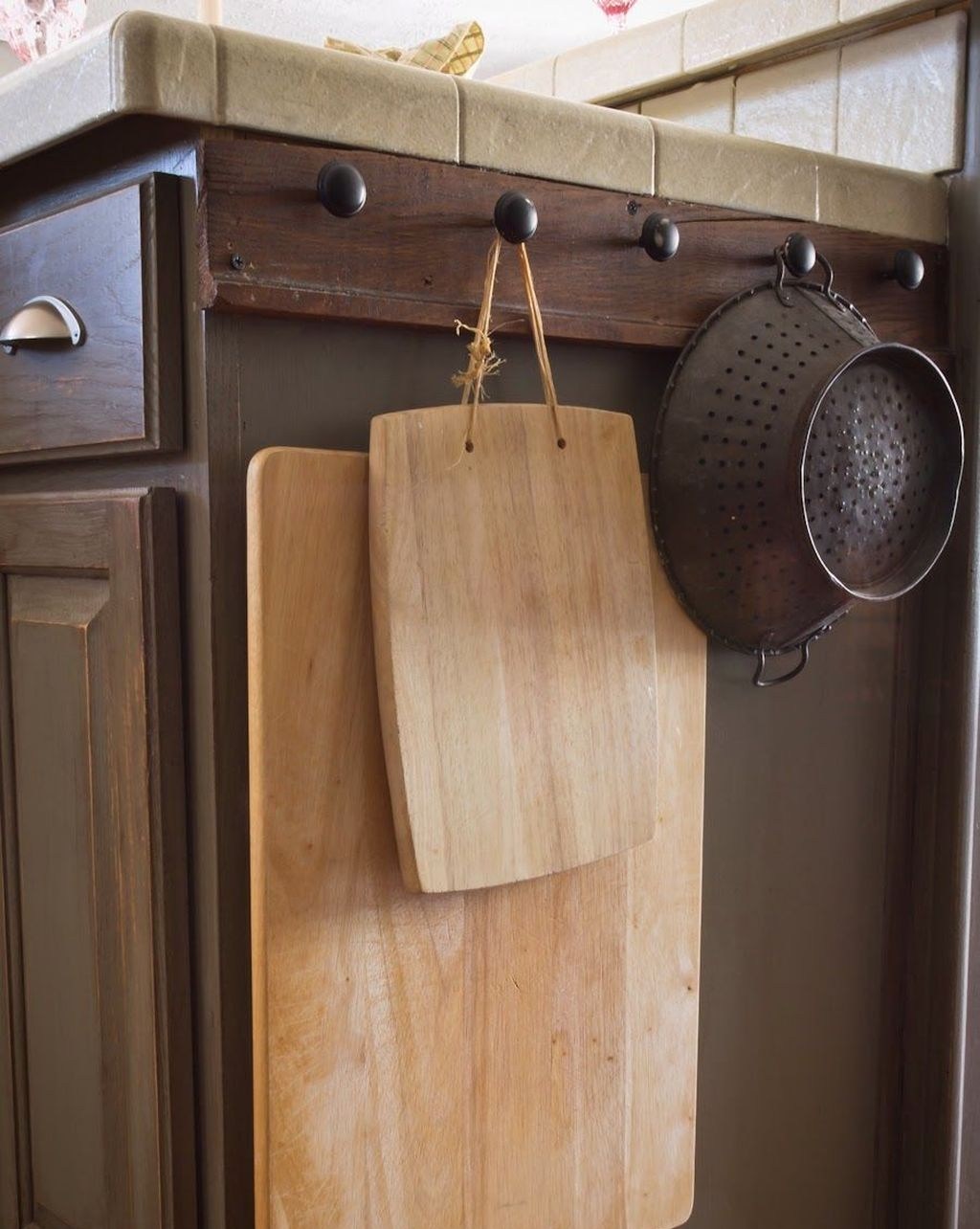 Tận dụng mặt bên của tủ dưới để lắp đặt những chiếc núm gỗ chắc chắn để treo vật nặng.