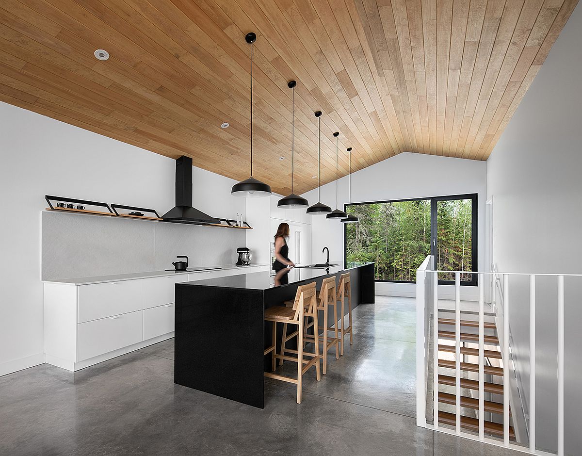 Phòng bếp thiết kế tối giản với gam màu trắng chủ đạo cho màu sơn tường, tủ bếp, nổi bật là đảo bếp màu đen làm điểm nhấn.