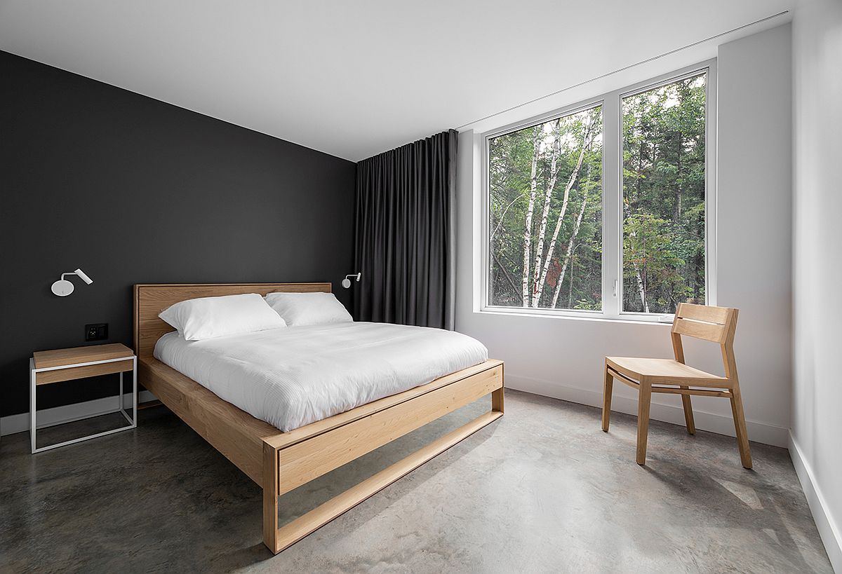 Phòng ngủ ở tầng 1 có thiết kế nhẹ nhàng thanh lịch, nội thất đơn giản nhưng tiện nghi với gam màu trắng và xám đậm ở bức tường và rèm cửa. 