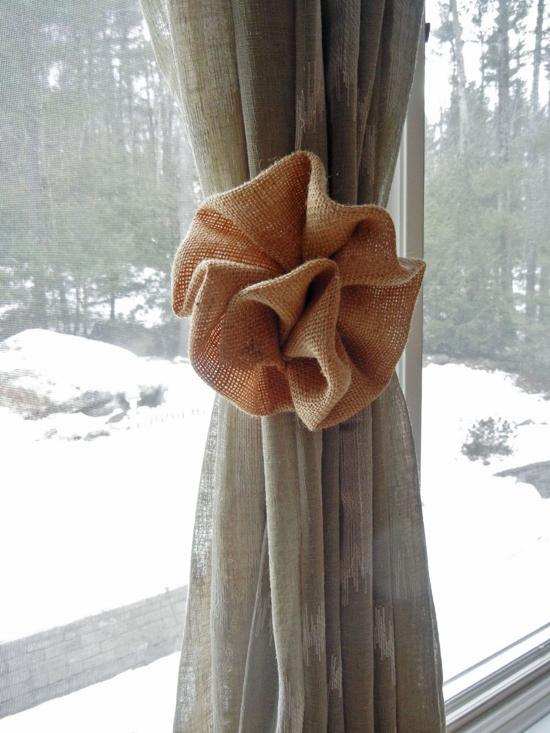 Bên khung cửa sổ nhìn ra khung cảnh mùa Đông với tuyết rơi trắng xóa bên ngoài, chiếc rèm màu ghi đính bông hoa vải bố  nâu nhạt cho cảm giác ấm áp lạ kỳ!