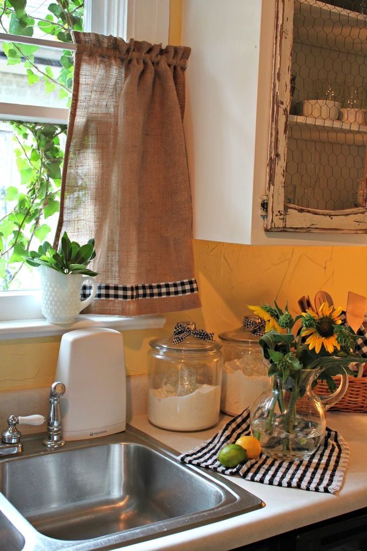 Tại khu vực bồn rửa, tấm rèm vải bố được thiết kế một tấm diềm ngang qua ô cửa, điểm xuyết vải họa tiết ca rô, mẫu họa tiết đặc trưng cho phong cách vintage.
