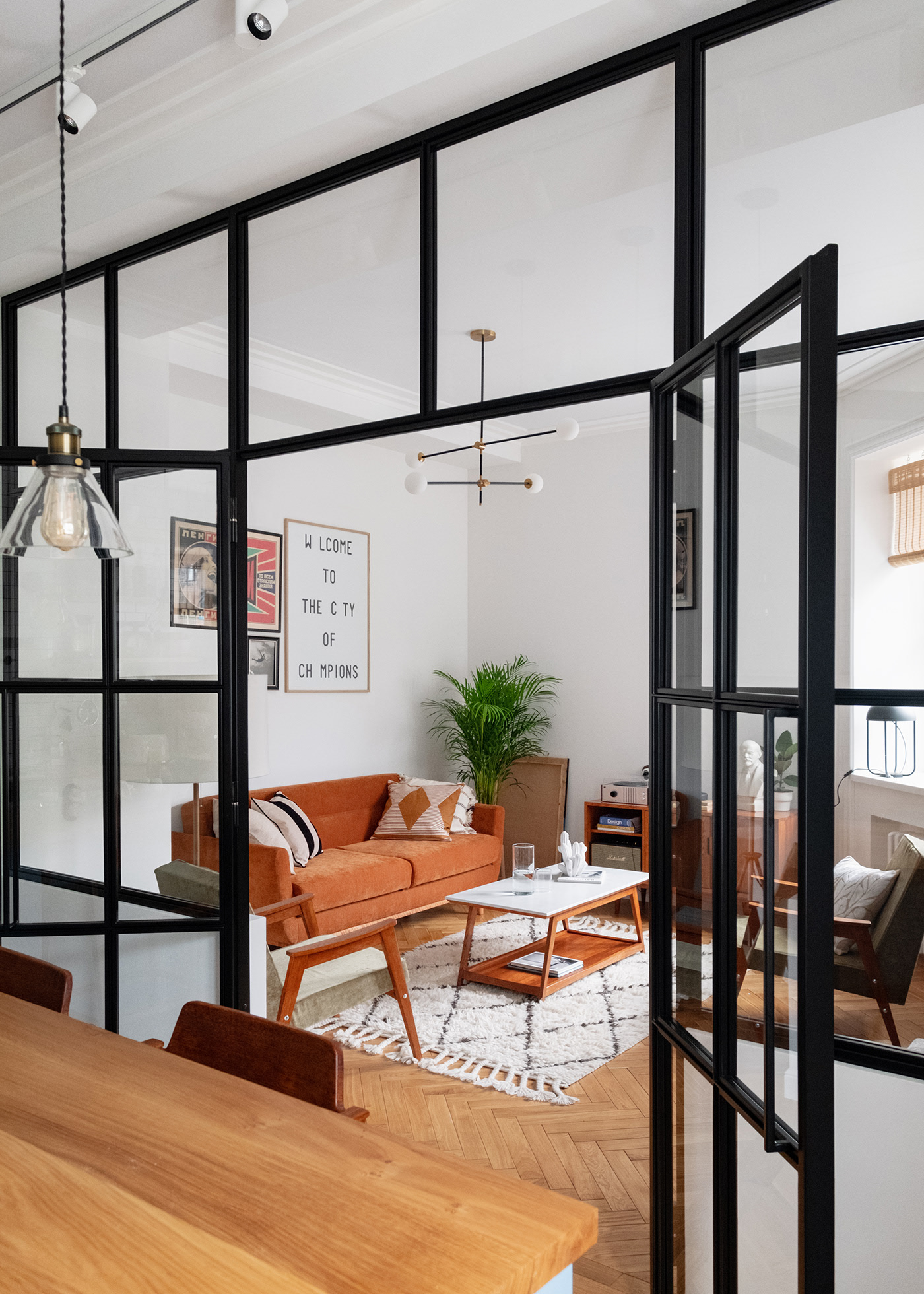 Bức tường kính trong suốt với viền khung màu đen giúp phân chia phòng khách và phòng bếp mà vẫn đảm bảo sự thông thoáng cũng như đón nhận ánh sáng tự nhiên.
