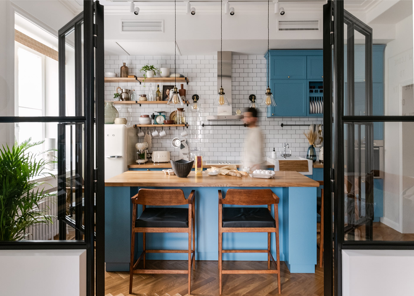 Để tạo sự nổi bật cũng như dịu mắt cho khu vực nấu nướng, gam màu xanh lam đã được sử dụng cho tủ lưu trữ và đảo bếp, xung quanh là gạch ốp màu trắng sáng bóng.