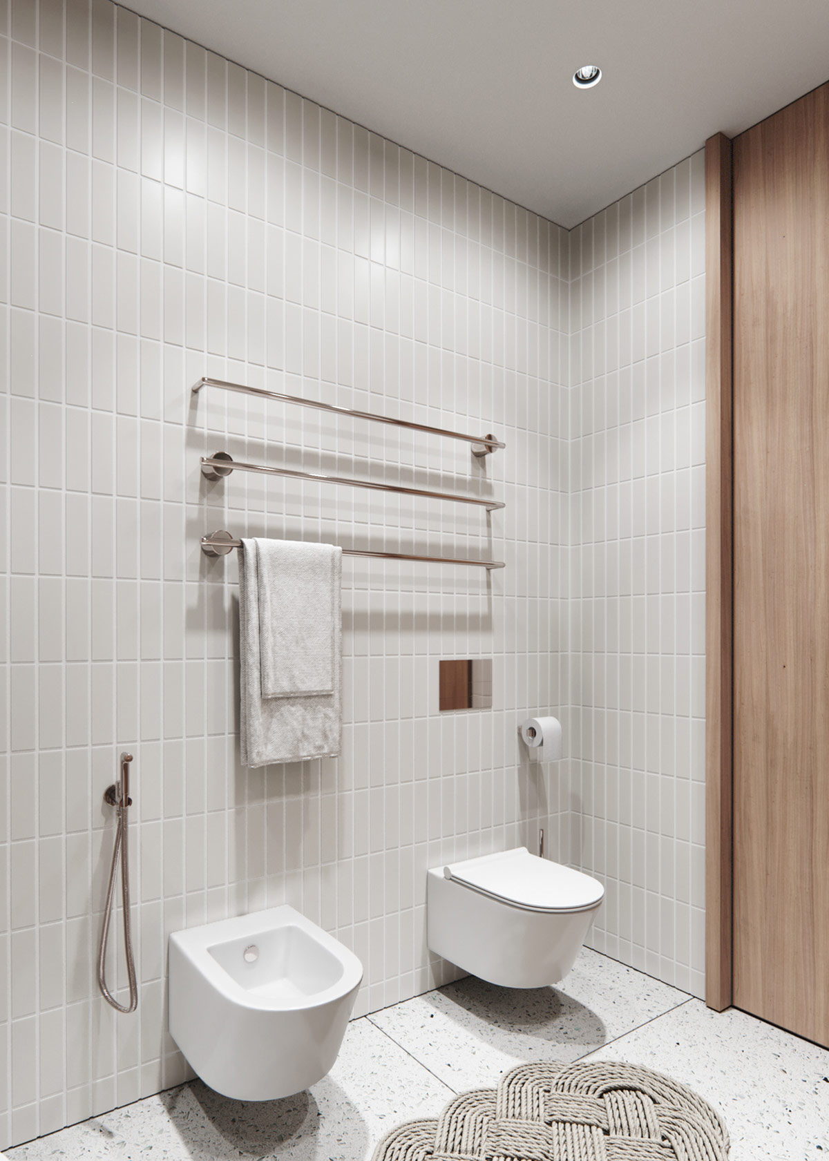 Những chiếc thanh ngang bằng kim loại treo khăn tắm cùng bồn toilet gắn tường nhằm giải phóng diện tích mặt sàn cho không gian thoáng đãng hơn.