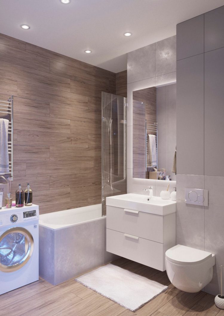 Phòng tắm sử dụng đèn Led âm trần, sàn nhà và tường được lát gỗ với đường vân tự nhiên cho cảm giác ấm áp. Máy giặt được bố trí ở góc cuối bồn tắm nằm, cửa kính trong suốt phân vùng bồn tắm với khu vực toilet. 